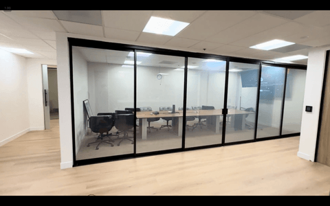 Switchable smart film on a modern commercial conference room demonstrating privacy spec integrated at the architectural glazing level for natural light management