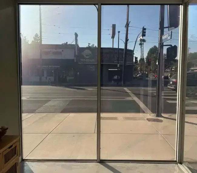 Comparison view of switchable PDLC smart film on a storefront in clear and frosted states for after-hours privacy